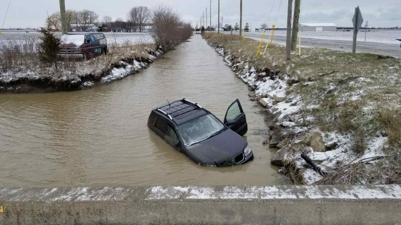 A vehicle slid into a ditch full of water on Lighthouse Road and Tecumseh Road in Lakeshore, Ont., Tuesday, April 17, 2018. (Courtesy OPP)