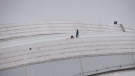 Workers examine a hole in top of the Rogers Centre as the area around the CN Tower is closed off due to reports of falling ice in Toronto on Monday, April 16, 2018. THE CANADIAN PRESS/Cole Burston