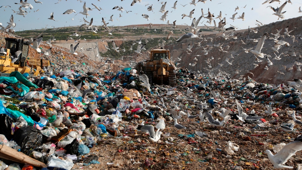 earthmovers push mountains of garbage