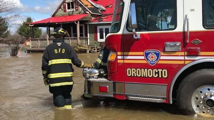 Members of the Oromocto Fire Department had to wade through waist-deep flood waters as they battled a blaze Sunday morning. (Oromocto Fire Department/Facebook)