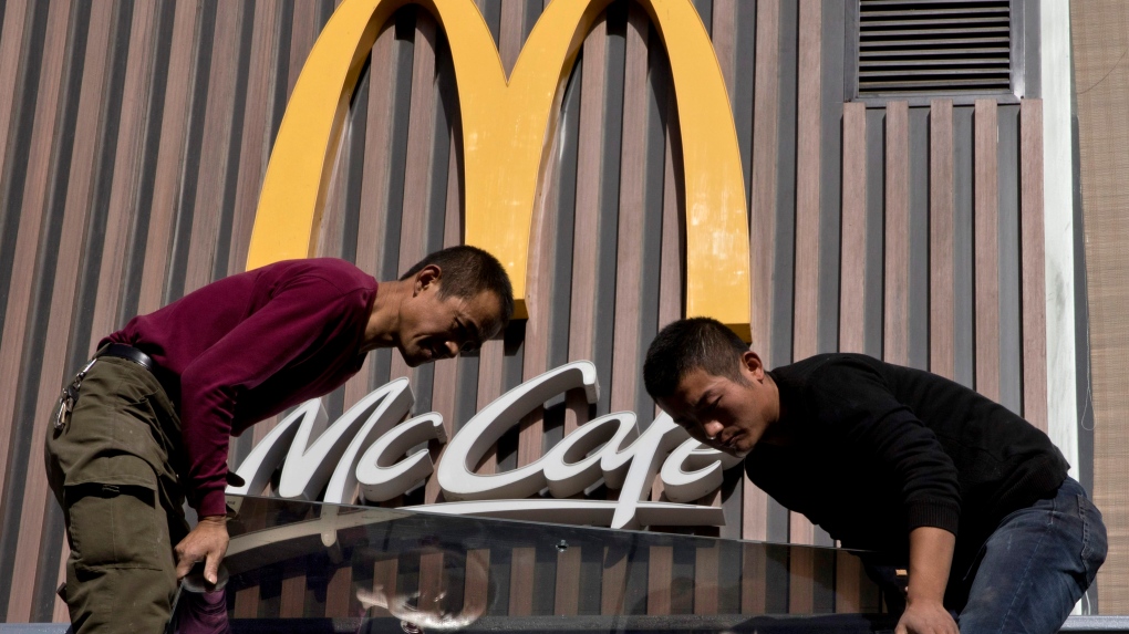 Chinese workers install McDonald's sign in Beijing