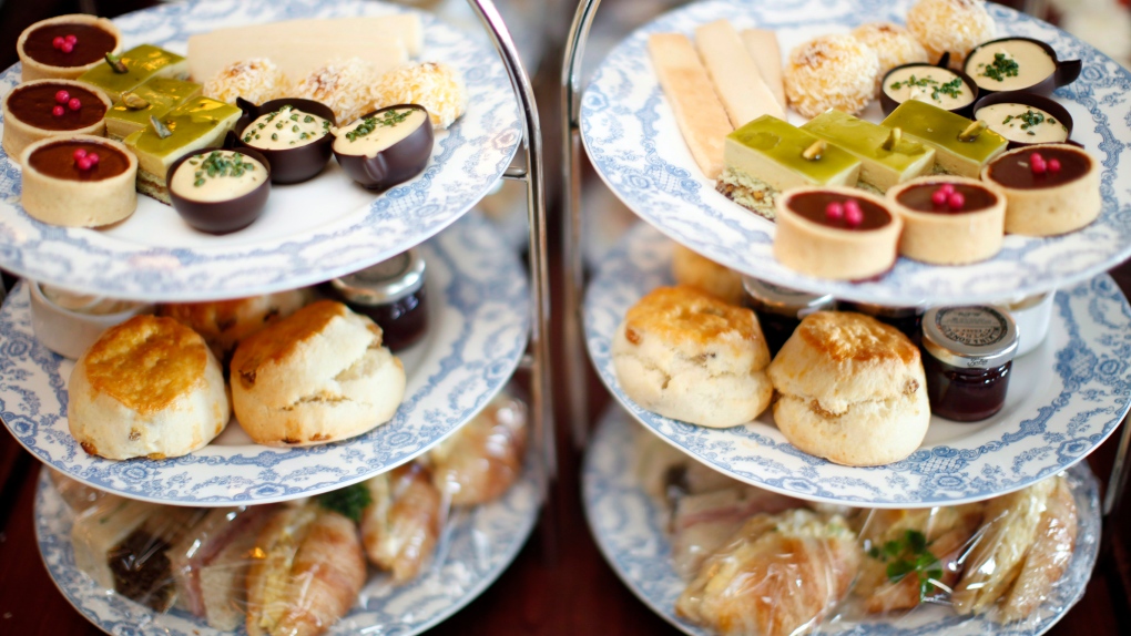 A tray of pastries, scones and sandwiches