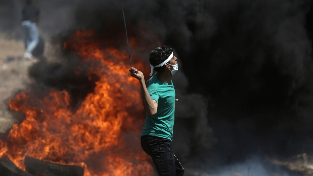 A Palestinian protester hurls stones