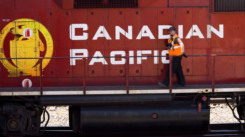 A Canadian Pacific Railway employee walks along the side of a locomotive in a marshalling yard in Calgary, Wednesday, May 16, 2012. 