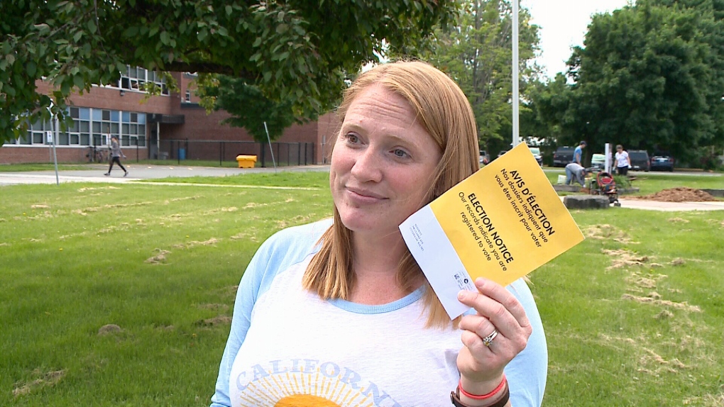  Amber Last holds up voter card she received.