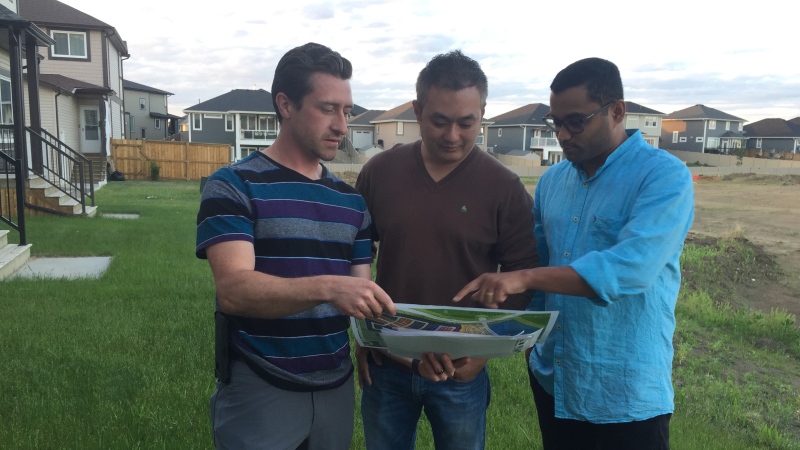 Rosewood residents look at a new building proposal that would interfere with plans for a road in front of their homes. Residents are petitioning against the plans. (Laura Woodward/CTV Saskatoon)