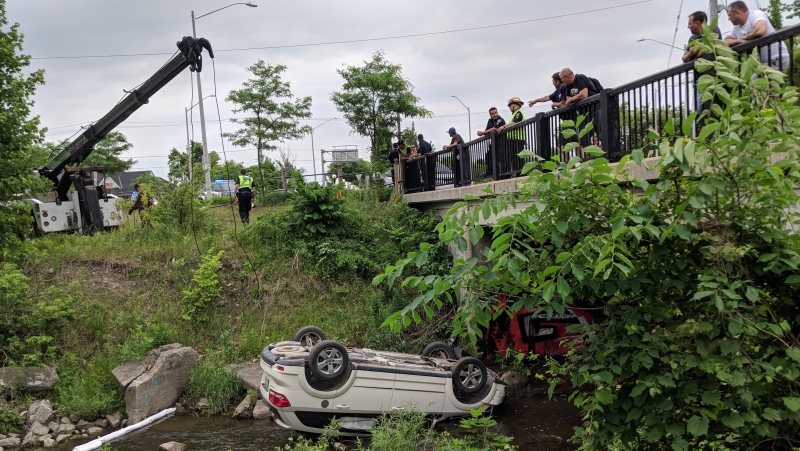 A car flipped into a creek near Bridge and Lancaster streets in Kitchener on Monday, June 18, 2018. (Marta Czurylowicz / CTV Kitchener)