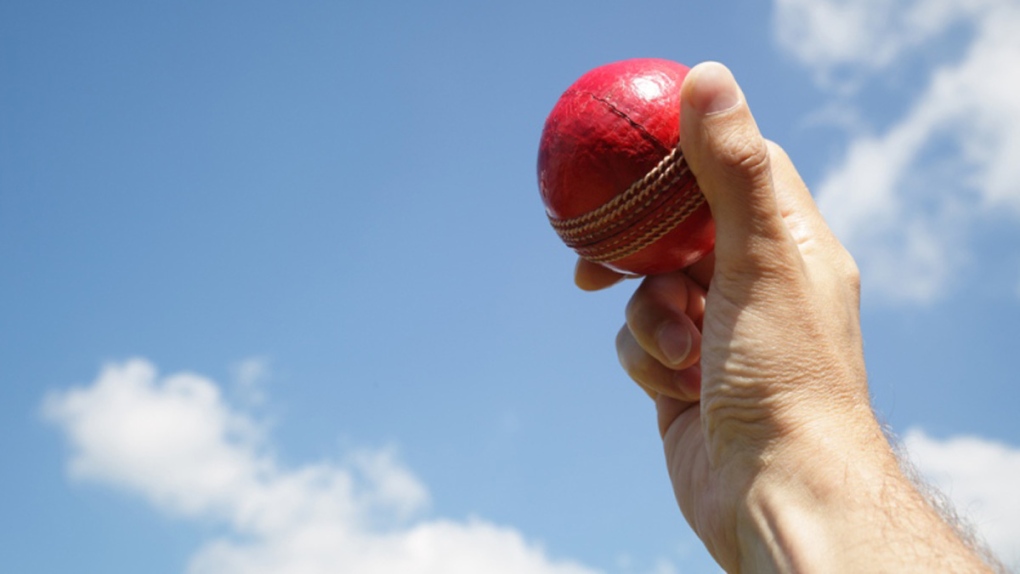 A man holds a cricket ball
