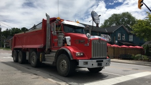 Dump trucks haul fill on a Cookstown, Ont. street. (KC Colby / CTV Barrie)