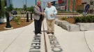 Waterloo Mayor Dave Jaworsky and Kitchener Mayor Berry Vrbanovic shake hands over the border of their two cities at The Boardwalk. (Dave Jaworsky / Twitter)