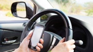 A driver uses their mobile phone while driving in this undated file image. (File)