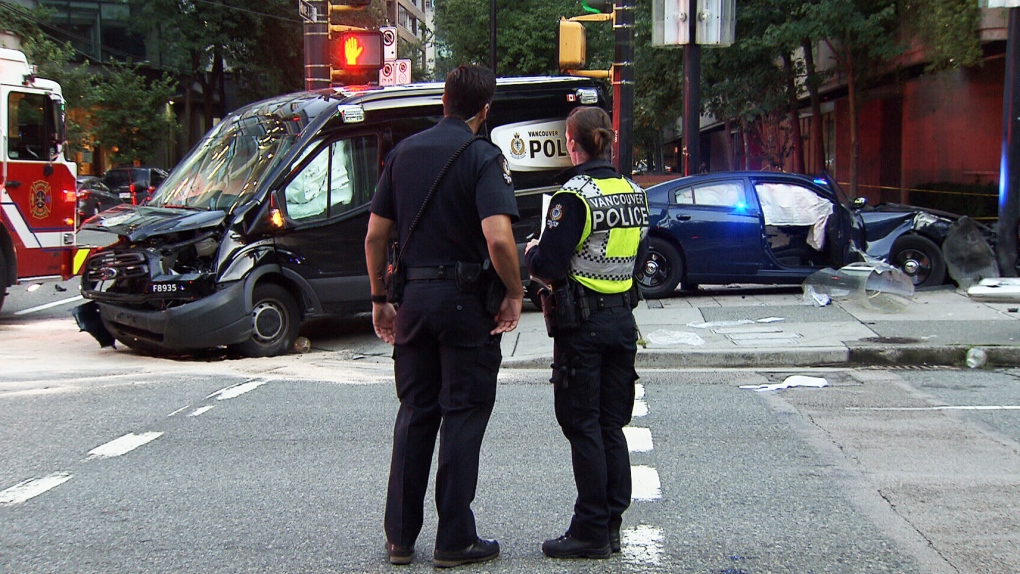 Police officers examine crash of VPD vehicles