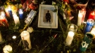 Candles and a framed photograph of slain rapper Jahvante Smart are placed in the Metropolitan Church park during a vigil in Toronto on Monday, July 2, 2018. THE CANADIAN PRESS/Christopher Katsarov