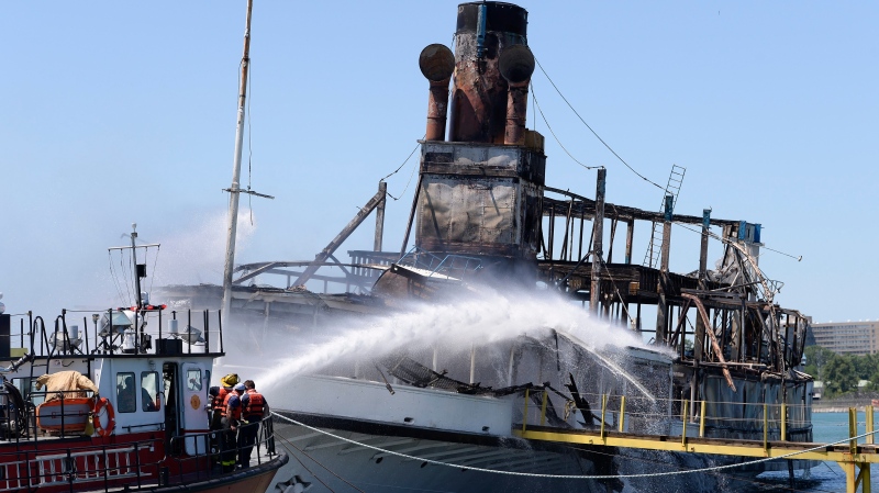 Members of the Detroit Fire Department Marine Corps spray water on a Boblo boat that was on fire at a marina, Friday, July, 6, 2018, in Detroit. (Clarence Tabb Jr./Detroit News via AP)