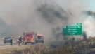 Firefighters are seen battling a blaze on Highway 401 in Port Hope. 