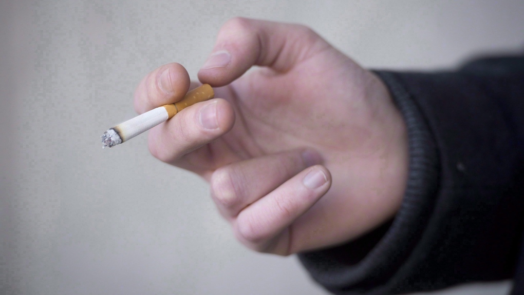 A smoker holds a cigarette