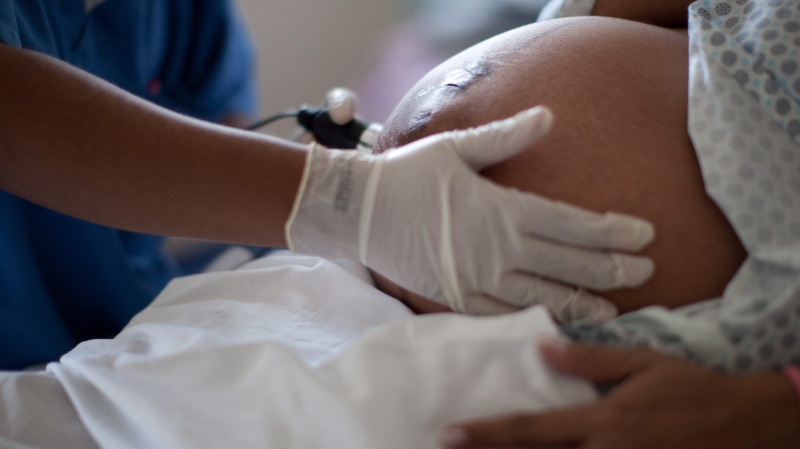 In this Wednesday, July 25, 2012 photo, a pregnant woman is examined as she waits to give birth at a public hospital in Rio de Janeiro, Brazil. (AP Photo/Felipe Dana)
