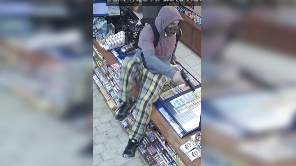 A man in pyjama pants robbing a store