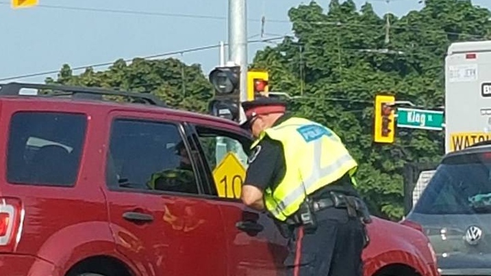 A police officer speaking to a driver.
