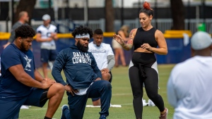 In this July 28, 2018, file photo, Dallas Cowboys offensive tackle La'el Collins, left and running back Ezekiel Elliott, center, listen to yoga instructor Stacey Hickman, right, as the team does some flexibility exercises at NFL football training camp in Oxnard, Calif. (AP Photo/Gus Ruelas, File)