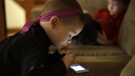 Nolan Young, 3, front, looks at a smart phone while his brother Jameson, right, 4, looks at a smart tablet at their home in Boston, on Jan. 27, 2014. (Steven Senne / AP)
