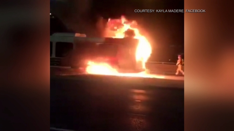 Flames engulf the back of an OC Transpo bus while it was traveling eastbound on the Queensway Monday night. Witnesses say no one was injured. (Facebook: Kayla Madere) 