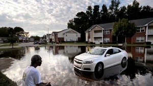 Augustin Dieudomme looks out at the flooded entrance to his apartment complex near the Cape Fear River as it continues to rise in the aftermath of Hurricane Florence in Fayetteville, N.C., Tuesday, Sept. 18, 2018. (AP Photo/David Goldman)