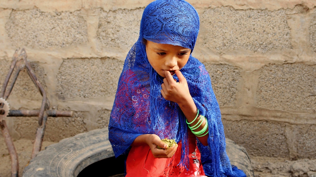 A hungry girl eats boiled leaves in Yemen