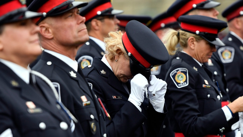 A police officer adjusts her hat before the Canadian Police and Peace Officers Memorial Service on Parliament Hill in Ottawa on Sunday, Sept. 30, 2018. THE CANADIAN PRESS/Justin Tang
