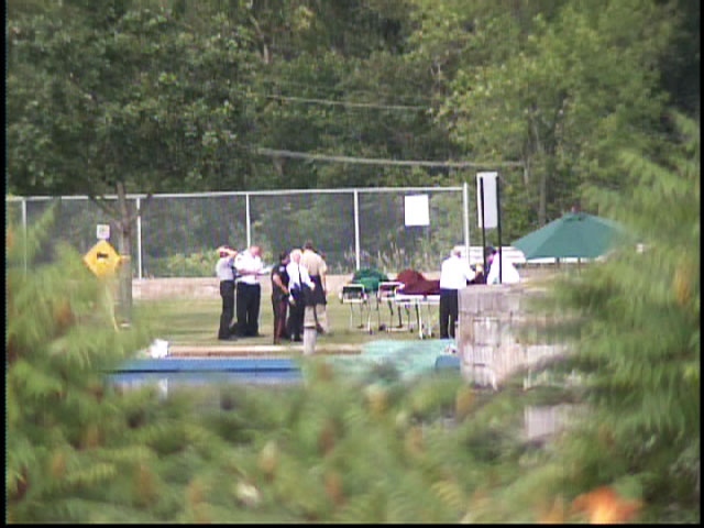 Police investigate a crime scene Northeast of Kingston, Ont., after four bodies were found in a submerged car on Tuesday, June 30, 2009.