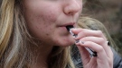 In this April 11, 2018, file photo, an unidentified 15-year-old high school student uses a vaping device near the school's campus in Cambridge, Mass. (AP Photo/Steven Senne, File)