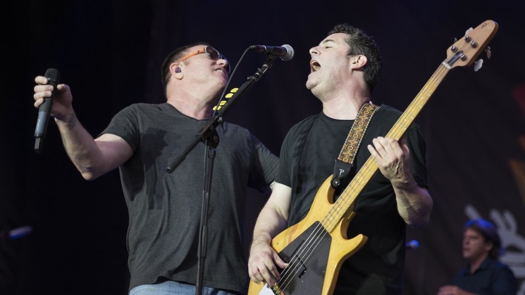 Two members of Smashmouth sharing the stage