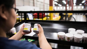 A worker examines cannabis products at the Ontario Cannabis Store distribution centre in an undated handout photo. (THE CANADIAN PRESS/HO-Ontario Cannabis Store)