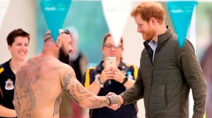 In this June 8, 2017, file photo, Britain's Prince Harry, right, shakes hands with Australian army veteran Tyronne Gawthorne during a demonstration at the the Aquatic Centre in Sydney. (AP Photo/Rick Rycroft, File)