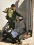 n Israeli soldier gives gives water to a blindfolded and handcuffed Palestinian prisoner after he and others were arrested during an Israeli army operation inside the Gaza Strip, and brought to an area on the Israel Gaza border Thursday , July 12, 2007.  (AP / Tsafrir Abayov)
