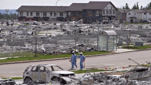 Workers put out markers around a devastated area of Timberlea in Fort McMurray Alta, on Thursday, June 2, 2016. Newly published research suggests the fire cast a lasting shadow over the lives of many residents who are still experiencing elevated rates of depression and related mental-health problems. THE CANADIAN PRESS/Jason Franson
