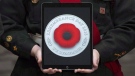 A cadet holds a tablet showing the digital poppy during a ceremony marking the start of the Canadian Legion's Remembrance Day poppies at the Beechwood National Memorial centre Monday, October 22, 2018 in Ottawa.THE CANADIAN PRESS/Adrian Wyld