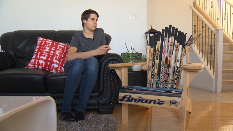 Peyton Kalbfleisch sits next to one of the chairs he had made out of hockey sticks, which he sells to the public for $150 each and donates $30 of the proceeds to the Glenrose Rehabilitation Hospital. 