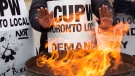 Striking Canada Post workers keep their hands warm as they picket at the South Central sorting facility in Toronto on Tuesday, November 13, 2018. (Frank Gunn / THE CANADIAN PRESS)