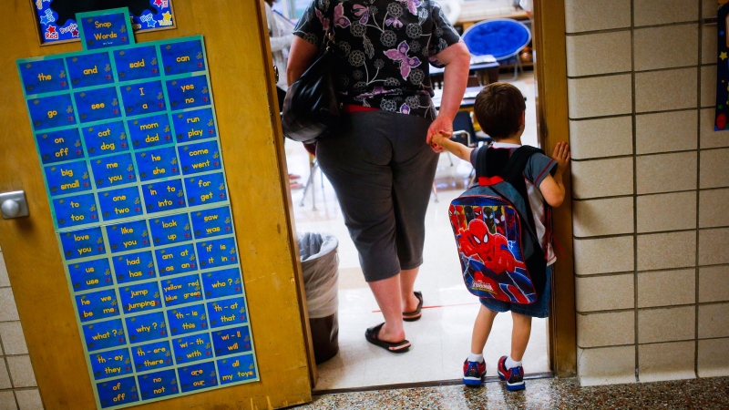  In this Sept. 8, 2015 file photo, a reluctant student is pulled into the first day of kindergarten at an elementary School in Clio, Mich. (Christian Randolph/The Flint Journal via AP, File)