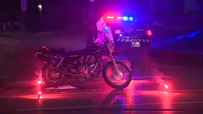 A motorcycle silhoutted lit up by police lights