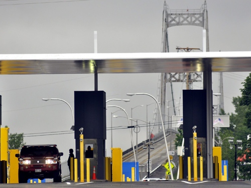 A United States Border Control Agent conducts a routine inspection with a car exiting the Seaway International Bridge traveling from Cornwall Island at the Massena International Plaza near Massena, NY, Friday, June 19, 2009. (AP / Heather Ainsworth)