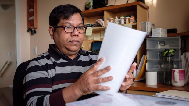 Nalliah Balachandran sorts through some of the legal documents he has accumulated at his home in Calgary, Alta., Tuesday, Dec. 4, 2018.(THE CANADIAN PRESS/Jeff McIntosh)