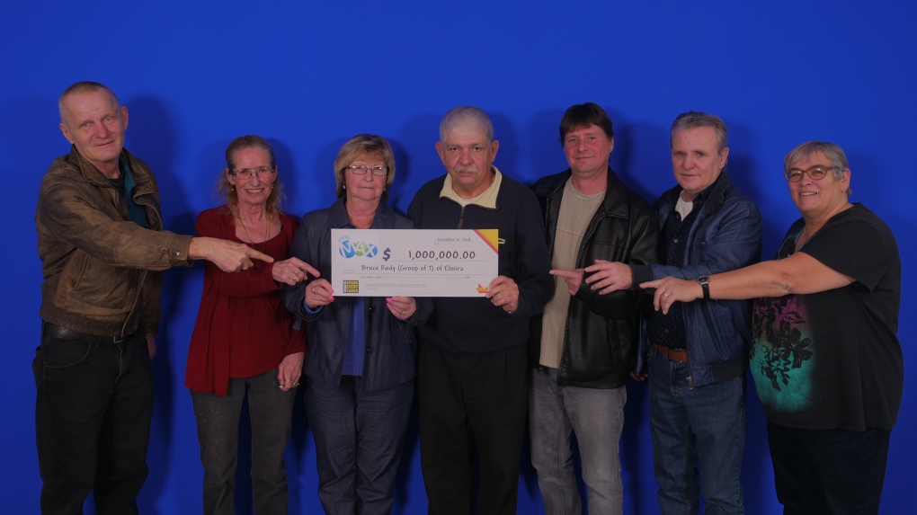The group of 7 posing with their $1 million cheque