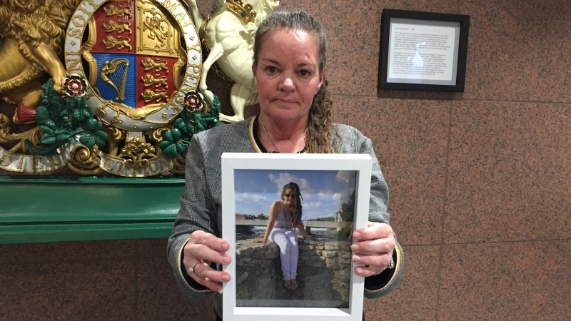 Jenny Devoe holding a photo of her daughter, Lindsay, who died of a drug overdose in 2018.