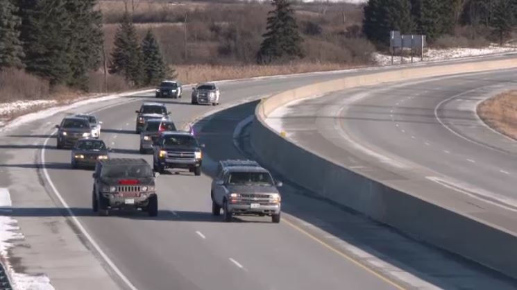 Pipeline protesters, escorted by OPP cruisers, slow traffic along Highway 401 near Kitchener, Ont. on Friday, Jan. 11, 2019.
