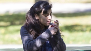 A woman smokes cannabis in a Toronto park on first day of legalization of cannabis across Canada on October 17, 2018. THE CANADIAN PRESS/Chris Young