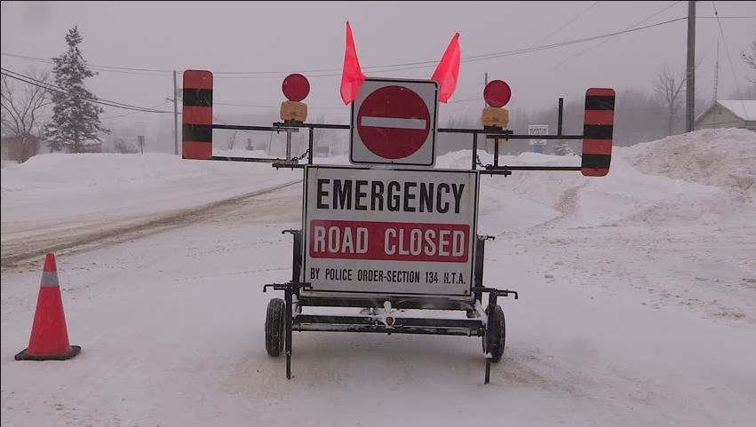 An emergency road closed sign in the winter