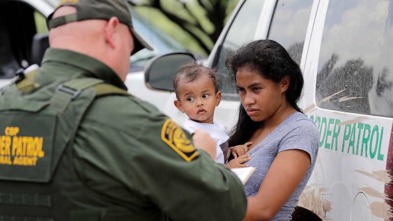 In this June 25, 2018, file photo, a mother migrating from Honduras holds her 1-year-old child as surrendering to U.S. Border Patrol agents after illegally crossing the border near McAllen, Texas. (AP Photo/David J. Phillip)