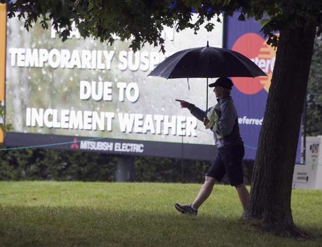 A spectator walks the course during a rain delay at the Canadian Open Golf championship in Oakville, Ont. on Thursday, July 23, 2009. (Frank Gunn / THE CANADIAN PRESS)  